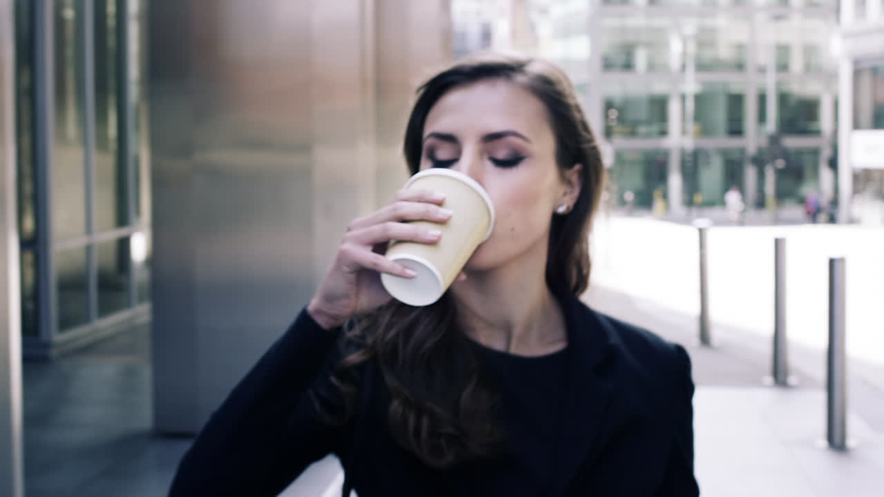 atractiva mujer de negocios viajera bebiendo café caminando por la ciudad de londres