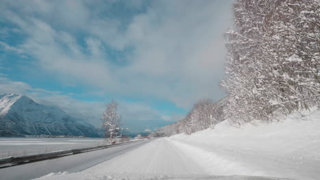 POV-Video-Einer-Fahrt-Bei-Tageslicht-Durch-Die-Verschneiten-Straßen-Der-Westlichen-Fjorde-Norwegens,-Umgeben-Von-Hohen,-Schneebedeckten-Bergen-Mit-Bäumen