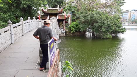 hombre pescando en el puente cerca del templo