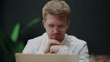 adult-man-with-glasses-is-reading-from-laptop-display-portrait-indoors-financial-analytic-or-businessman