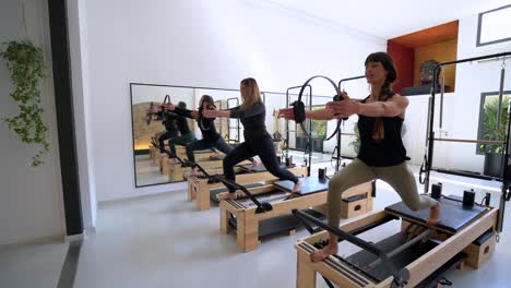 Company-of-women-doing-lunges-on-pilates-reformer