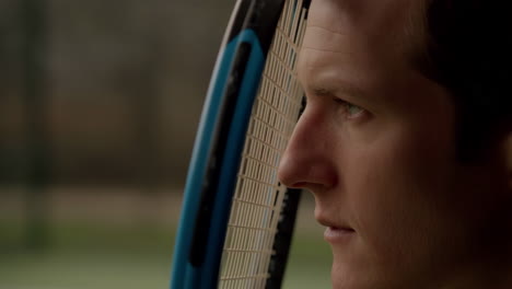 close-up profile of a man with a tennis racket