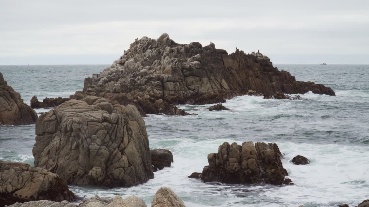 Onde che si infrangono su formazioni rocciose sulla spiaggia in una giornata nuvolosa sulla costa del Pacifico