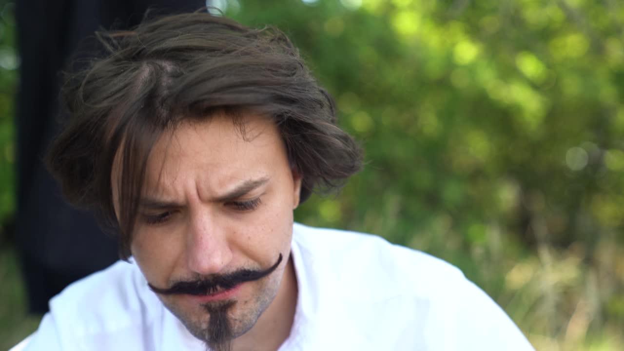 헝가리 시인 산도르 페토피 역을 맡은 배우가 간식을 먹고 그늘에서 쉬고 있습니다.