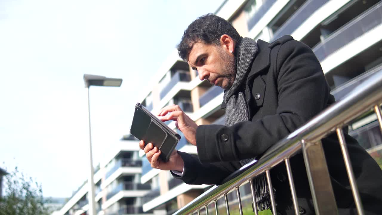 Man Using Digital Tablet Outdoors in Urban Setting
