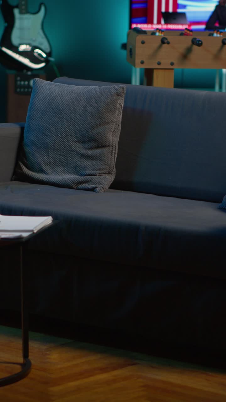 Tom stue med sofa og TV, der viser nyhedsanker