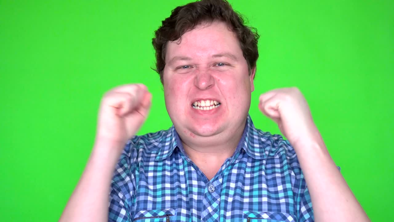 흥분한 승자가 뭔가를 이기는 것을 축하하고, 매우 행복한 젊은이가 그린 스크린에서 승자의 몸짓을 하고 있다.