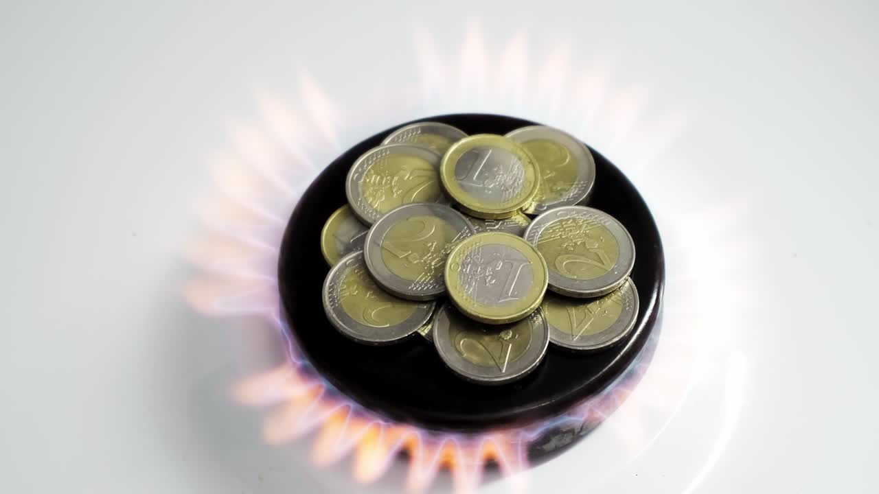 el concepto de la crisis del gas. las monedas de 2 euros están ardiendo en un quemador de la estufa de la cocina. el dinero en efectivo europeo. los altos precios de los recursos naturales. la llama del fuego. la deuda de los servicios públicos. la guerra de la energía.