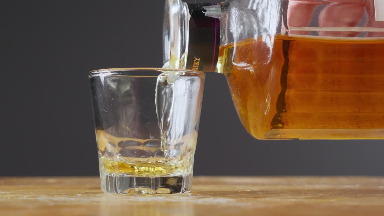 Pouring Japanese Whisky on shot glass in slow motion