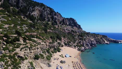 Tsambika-beach-in-Faliraki,-Rhodes-in-Greece-filmed-with-the-drone-from-above-with-Mediterranean-Sea-in-the-summer-holiday