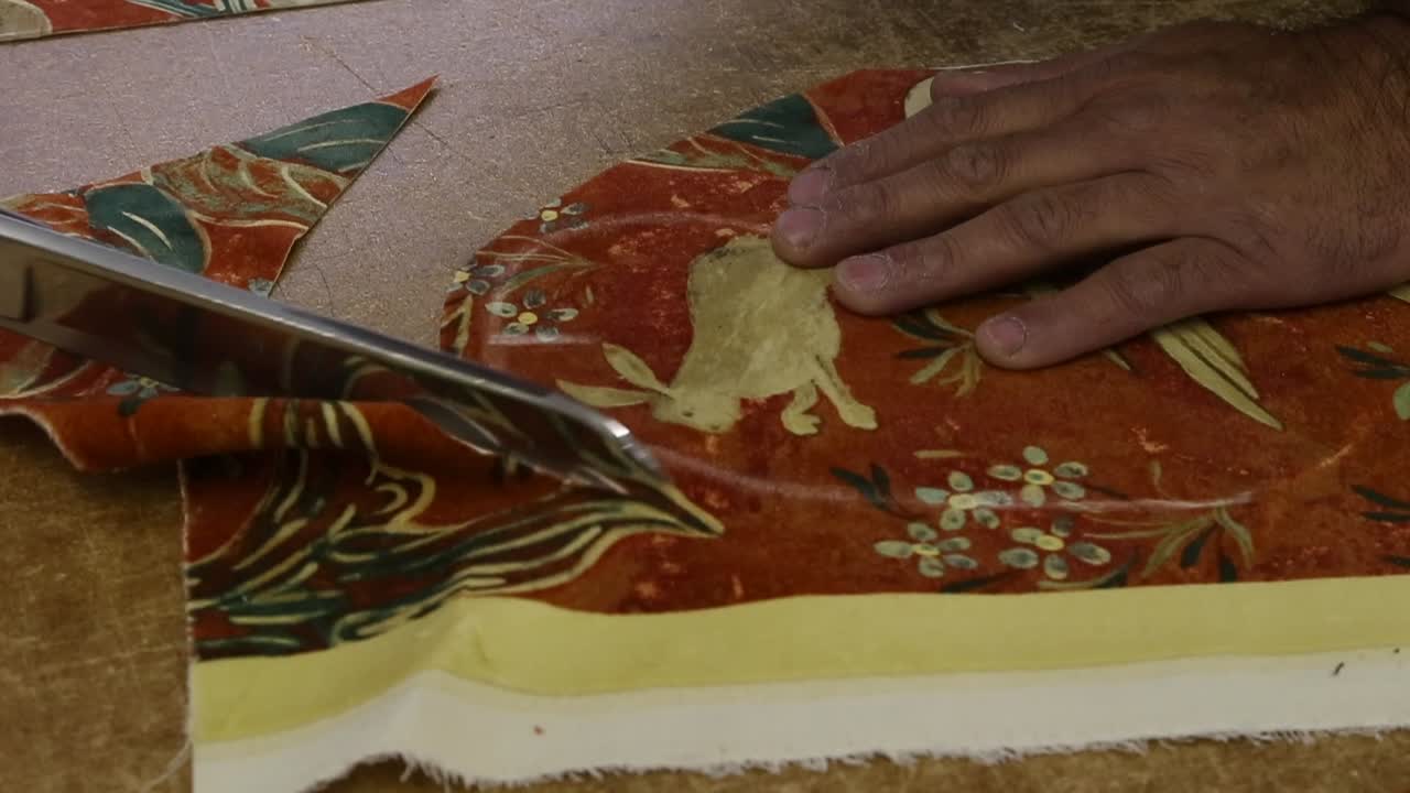cerca de las tijeras cortando alrededor del contorno del patrón para la tapicería