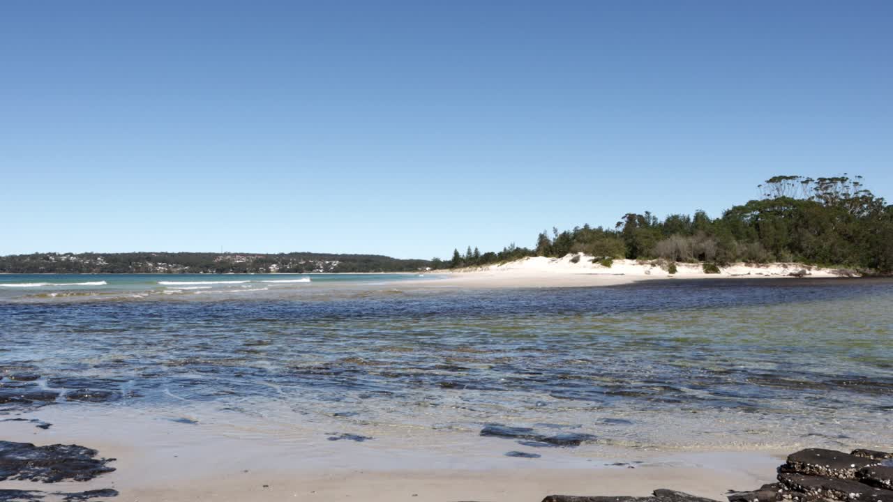 orilla rocosa de la playa en moona moona creek entrando en las aguas de la bahía de jervis en australia, disparo cerrado