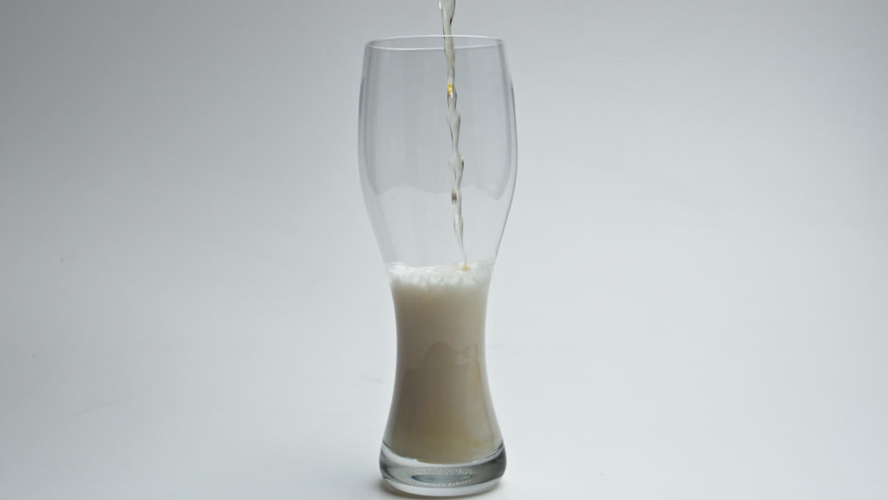 un recipiente de espuma líquida de alcohol sin filtrar para verter el vidrio de un jet de cerveza.