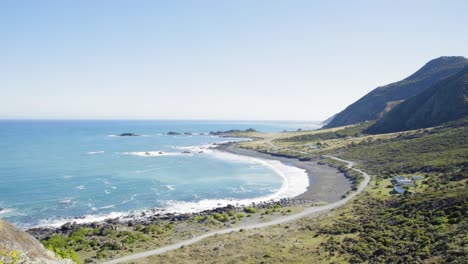 Zu-Einem-Zaun-Gehen,-Um-über-Eine-Klippe-Auf-Einen-Strand-Und-Das-Offene-Meer-Hinauszublicken