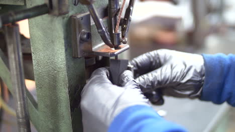 a worker using a machine to drill into a metal piece