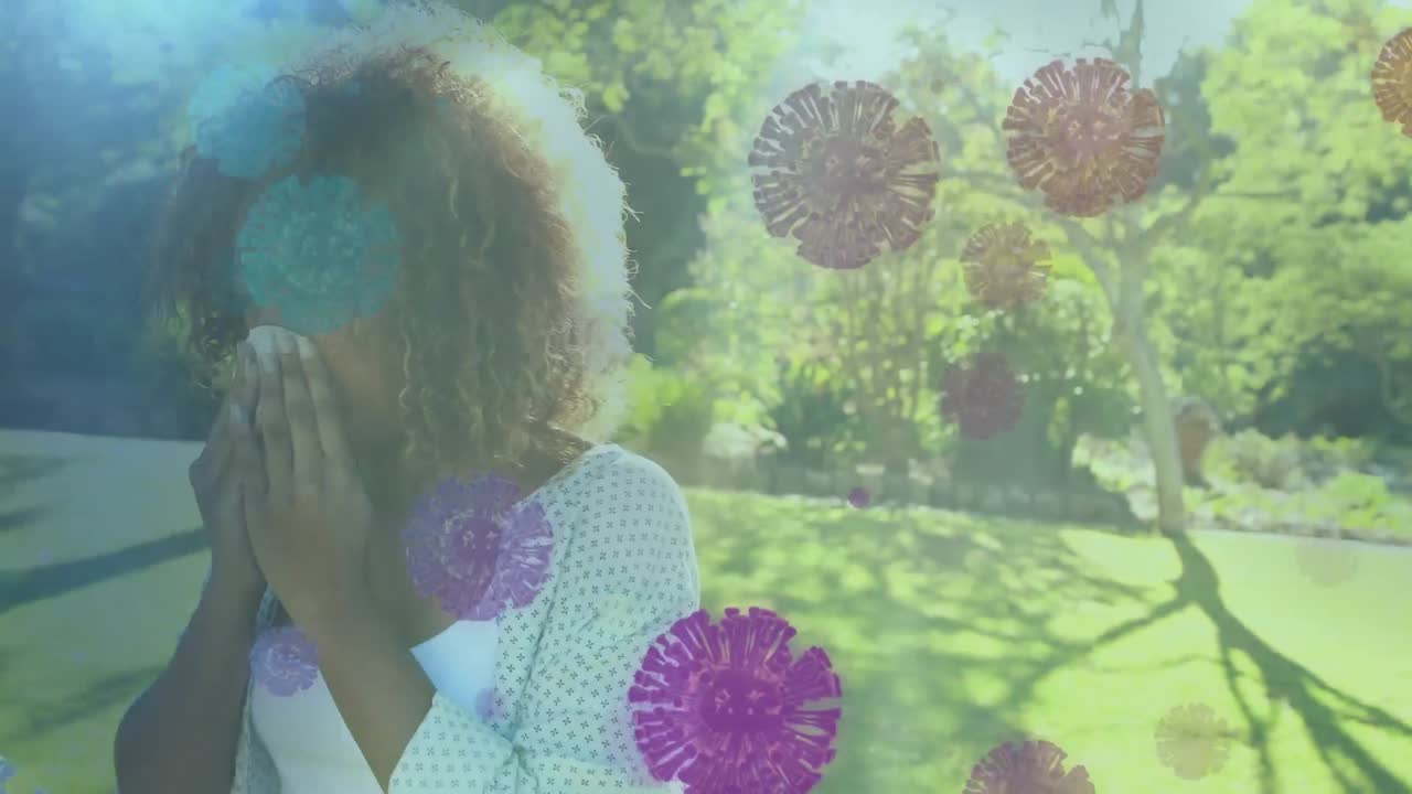 Mujer afroamericana sonándose la nariz sobre células flotantes de coronavirus Covid-19.