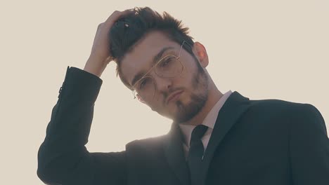 bearded guy with tie poses at bright sunlight slow motion