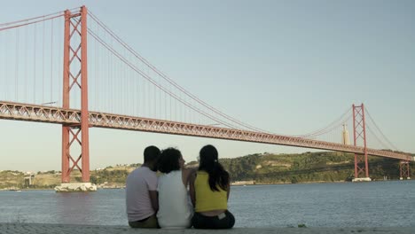 Back-view-of-friend-sitting-near-river