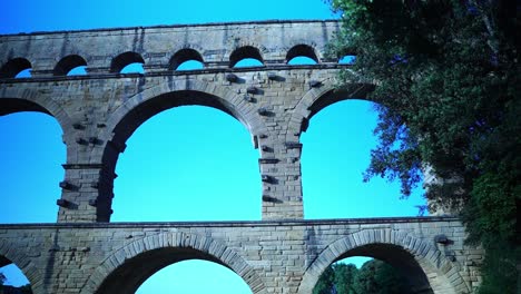 Pont-du-Gard-in-France-in-good-weather-behind-a-tree