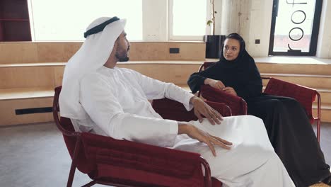 hombre y mujer guapos con ropa tradicional trabajando en una oficina de dubai