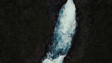 aerial clear blue waterfall river hlauptungufoss iceland, bird's eye top down view