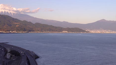 slow left pan across ocean, highway and mount fuji in japan