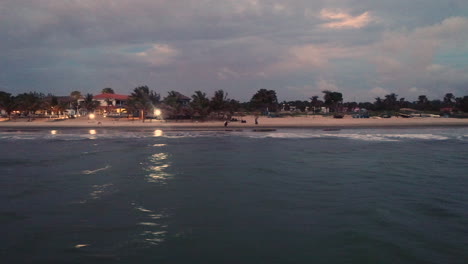 Una-Vista-Aérea-Baja-De-La-Playa-De-Senegambia-En-Serrekunda-Gambia-Al-Atardecer-Que-Muestra-Los-Complejos-Turísticos-De-Playa