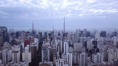 Stunning-high-aerial-shot-of-morning-in-city-centre-with-fog-and-blue-sky,-Sao-Paolo