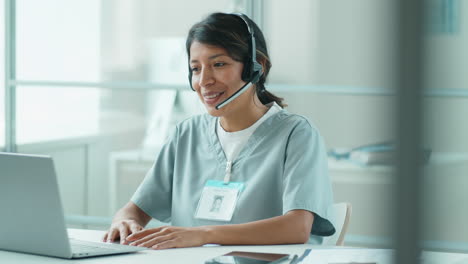 hispanic female doctor talking on online video call on laptop