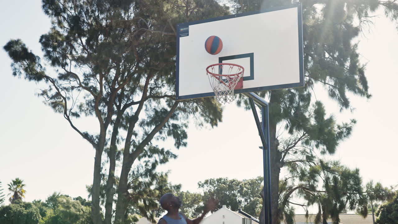 A man playing basketball in a park