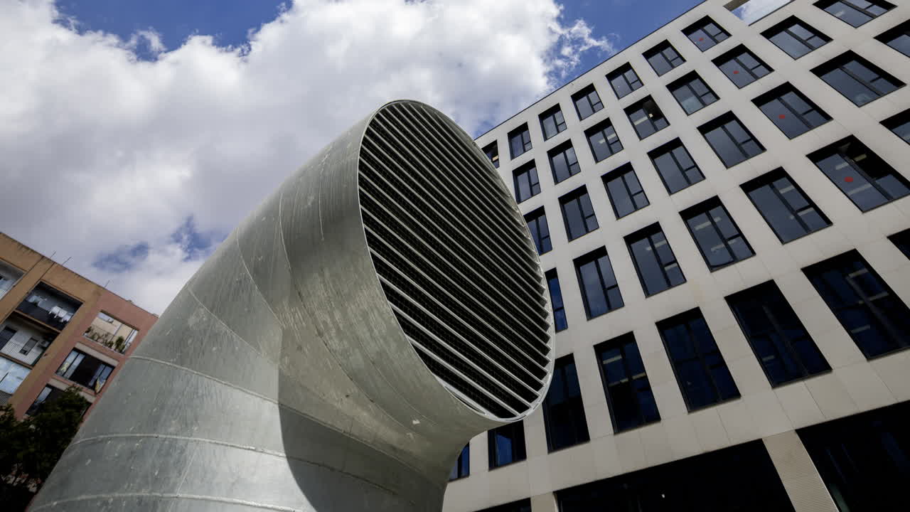 Old factory and industrial complex and air vent with passing clouds