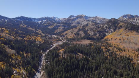 long, push and pull shots of a snowcapped mountain range with yellow aspens