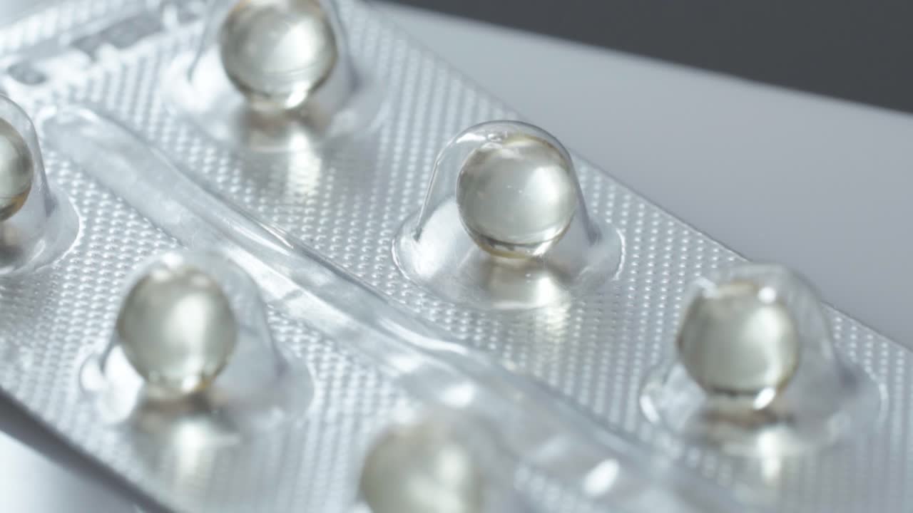 Macro close up of transparent softgel pills inside blister pack, pharmaceutical product detail