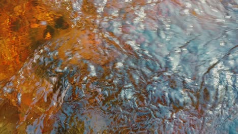 Corriente-De-Agua-Dulce-Sobre-Un-Lecho-De-Roca-Roja