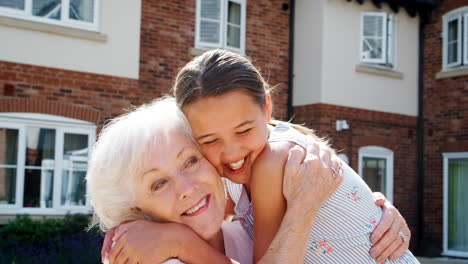 granddaughter greeting grandmother on visit to retirement home