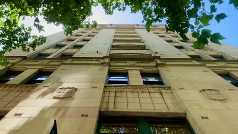 gothic new york style architecture limestone apartment view up to leafy blue sky