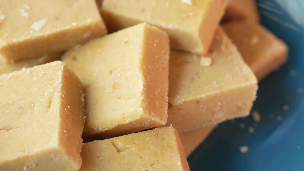 Cerca de dulce indio en un recipiente sobre la mesa.