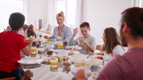 Dos-Familias-Disfrutando-Juntas-De-Una-Comida-En-Casa-Filmadas-En-Cámara-Lenta