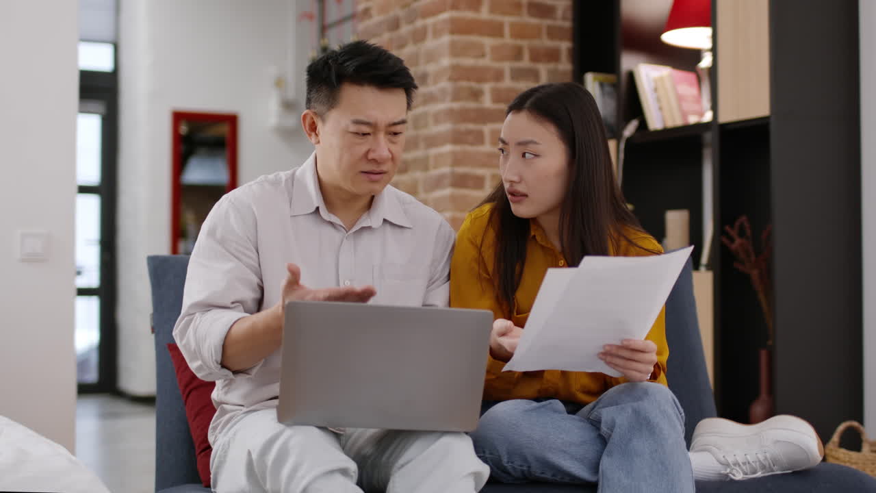 Couple reviewing financial documents at home