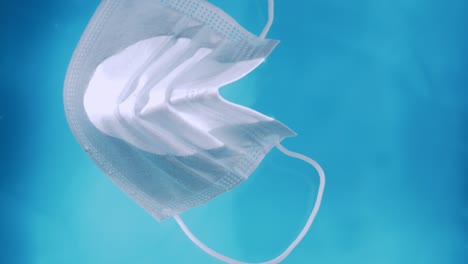 a medical protective mask on the water surface water pollution during the covid-19 crisis with ties slowly drifts on the surface of the water