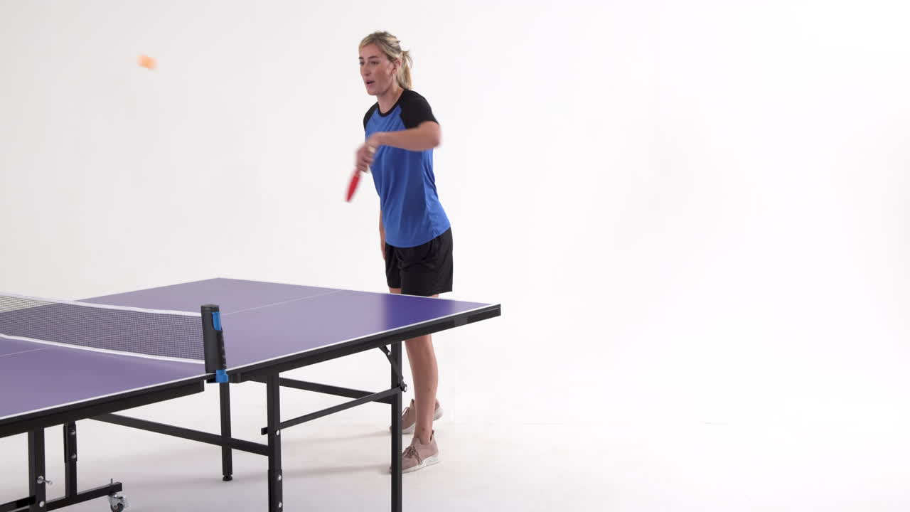 Female table tennis player serving and passing the ball on white background, copy space