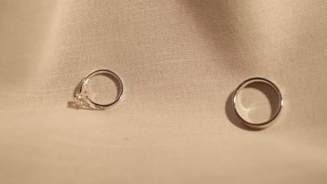 two gold rings on velvet fabric background