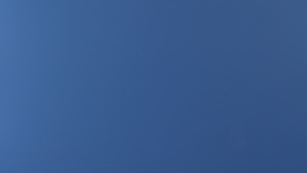 se ve una rebanada de pizza de pepperoni volando frente a una pantalla azul