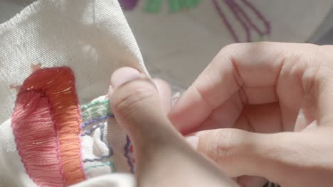 hands doing delicate needlepoint - isolated close up craft