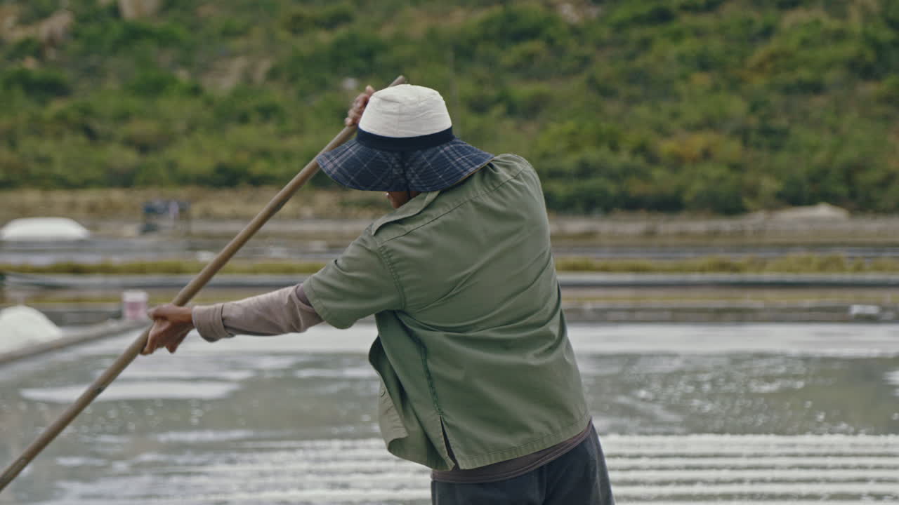 Worker engaged in salt production at an outdoor salt field