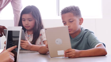 maestro con niños que usan tabletas en clase de escuela primaria
