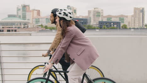 american man and woman riding bikes and talking to each other while going to work 1