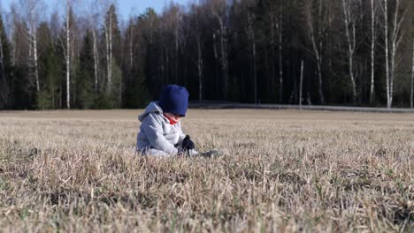 Kleinkind-Junge-Sitzt-Allein-Im-Ländlichen-Feld,-Frühling