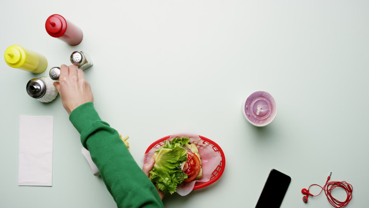 식당에서 햄버거와 감자김을 먹는 사람