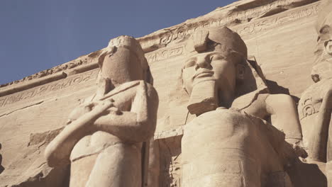 low shot of the abu simbel facade with big statues of osiris